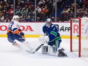New York Islanders' Mathew Barzal, left, scores the team's fifth goal against Vancouver Canucks goalie Jaroslav Halak during the first period of an NHL hockey game in Vancouver, on Wednesday, February 9, 2022.