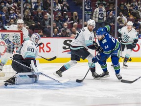 Seattle Kraken defenceman Adam Larsson (6) looks on as Vancouver Canucks forward Tyler Motte (64) scores on goalie Chris Driedger (60) in the first period at Rogers Arena.