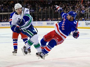 Vancouver Canucks left wing Nils Hoglander (21) and New York Rangers centre Ryan Strome (16) collide during the second period at Madison Square Garden.