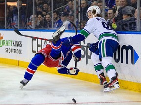 Vancouver Canucks right wing Vasily Podkolzin (92) hits New York Rangers defenceman Jacob Trouba (8) during the first period at Madison Square Garden.