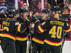 Vancouver Canucks defenseman Quinn Hughes (43) and forward J.T. Miller (9) and forward Bo Horvat (53) and forward Brock Boeser (6) and forward Elias Pettersson (40) celebrate Miller's first goal of the game against the Calgary Flames in the second period at Rogers Arena on Feb. 24, 2022.