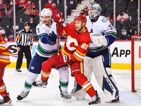 Canucks defenceman Luke Schenn comes to goalie Thatcher Demko’s aid, working over a screening Trevor Lewis of the Calgary Flames earlier this season.