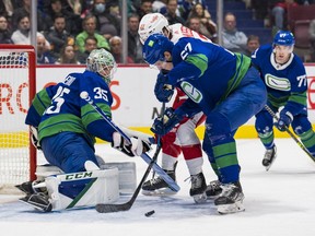 Vancouver Canucks goalie Thatcher Demko  makes a save on Detroit Red Wings forward Michael Rasmussen  as defenceman Tyler Myers (57) battles for the rebound in the second period at Rogers Arena March 17.