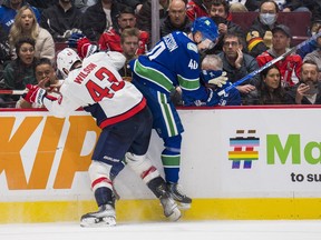 Canucks centre Elias Pettersson gets run into the boards by rugged Washington Capitals winger Tom Wilson during last Friday’s game at Rogers Arena. Pettersson has been out of the Canucks lineup since the Capitals game with an undetermined upper-body injury.