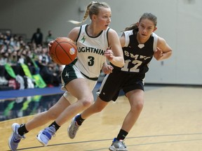 Langley Christian Lightning's Sydney Bradshaw tries to drive the ball while being guarded by St. Michaels University School Blue Jags' Avery Geddes during the Double A semifinal of the provincial championships at the Langley Events Centre on March 4, 2022.