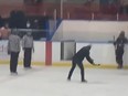A minor hockey coach is shown whipping a broken stick blade toward two referees in a cellphone video taken during a game at Talbot Gardens in the Southwestern Ontario town of Simcoe on March 2, 2022. Police say they escorted a coach from the rink and no charges were laid. Tillsonburg Minor Hockey officials say it is their understanding that one of their U13 house league/local league coaches is on leave pending an Ontario Minor Hockey Association investigation. (Screengrab/supplied)
