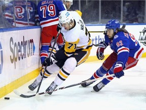 Evgeni Malkin #71 of the Pittsburgh Penguins battles with Mika Zibanejad #93 of the New York Rangers along the boards during the first period at Madison Square Garden on April 07, 2022 in New York City.