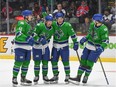 Abbotsford Canucks forward Danila Klimovich (left) and defenceman Jack Rathbone (second from left) celebrates with teammates after a goal was scored earlier this season.