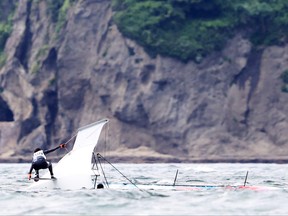 Eya Guezguez and Sarra Guezguez of Team Tunisia capsize during the Women's Skiff - 49er FX class race 1 on day four of the Tokyo 2020 Olympic Games at Enoshima Yacht Harbour on July 27, 2021 in Fujisawa, Kanagawa, Japan.
