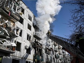 Firefighters work on a blaze at a building after Russian bombings on the eastern Ukraine town of Chuguiv on Feb. 24.