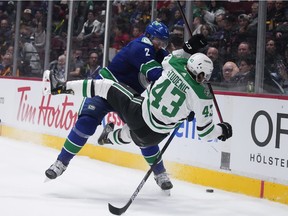 Vancouver Canucks' Luke Schenn (2) checks Dallas Stars' Marian Studenic (43) during the third period of an NHL hockey game in Vancouver, B.C., Monday, April 18, 2022.