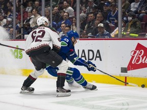 Arizona Coyotes defenceman J.J. Moser checks Vancouver Canucks forward Bo Horvat in the first period at Rogers Arena. Horvat later left the game with a lower body injury.