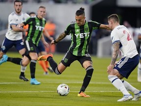 Austin FC forward Maxi Urruti (37) drives to score past Vancouver Whitecaps FC defender Jakob Nerwinski, front right, during the first half of an MLS soccer match, Saturday, April 23, 2022, in Austin, Texas.