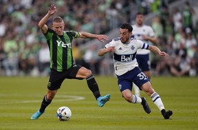 Austin FC midfielder Alex Ring, left, passes the ball past Vancouver Whitecaps FC striker Russell Teibert (31) during the first half of an MLS soccer match, Saturday, April 23, 2022, at Austin, TX.