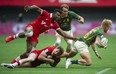 Canada's Matt Oworu and Phil Berna tackle South Africa's JC Pretorius in the HSBC World rugby Sevens Series at BC Place Stadium in Vancouver, BC Saturday, April 16, 2022.