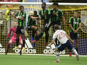 Austin FC defender Matt Besler (5) heads the ball after a shot by Vancouver Whitecaps FC midfielder Ryan Gauld (25) at B.C. Place on Sept. 4, 2021.