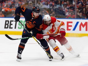 Connor McDavid #97 of the Edmonton Oilers is defended by Chris Tanev #8 of the Calgary Flames during the second period in Game 4 of the second round of the 2022 Stanley Cup Playoffs at Rogers Place on May 24, 2022 in Edmonton, Canada.