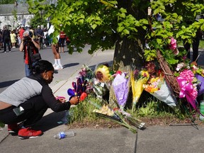 Flowers are left at a makeshift memorial outside of Tops market on May 15, 2022 in Buffalo, New York. Yesterday a gunman opened fire at the store, killing ten people and wounding another three. Suspect Payton Gendron was taken into custody and charged with first degree murder. U.S. Attorney Merrick Garland released a statement, saying the US Department of Justice is investigating the shooting "as a hate crime and an act of racially-motivated violent extremism."