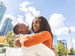 Happy man and woman embracing and laughing in Toronto.