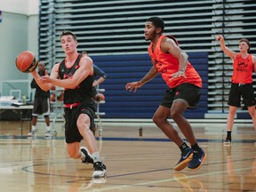 Guard Ty Rowell makes a pass under pressure from Geoffrey James at the Fraser Valley Bandits' training camp.