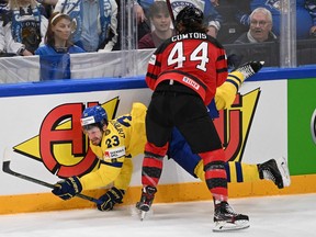 Sweden's defender Oliver Ekman-Larsson (L) and Canada's forward Maxime Comtois vie for the puck during the IIHF Ice Hockey World Championships quarterfinal match between Sweden and Canada in Tampere, Finland, on May 26, 2022. (Photo by Jonathan NACKSTRAND / AFP)