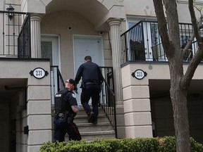Toronto Police officers enter a townhome on David Dunlap Circle, in Don Mills, where one occupant was injured by gunfire during an early morning home invasion and a second victim was wounded by a stray bullet in a nearby unit on Saturday, May 21, 2022.