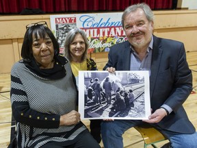 Barbara Burnet, Wendy Kyer and Shane Simpson with a Vancouver Sun photograph from 1971 at Admiral Seymour Elementary School in Vancouver. Burnet was one of the Militant Mothers of Raymur that occupied train tracks near the school in 1971 because they feared for the safety of their children trying to cross the tracks on their way to school. Kyer was a former student at the school who used to cross the tracks, as was Simpson.