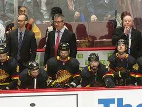 Vancouver Canucks assistant Jason King (back left) and Bruce Boudreau (right) will be behind the bench in 2022-23, but assistant Scott Walker (centre) won't be returning.