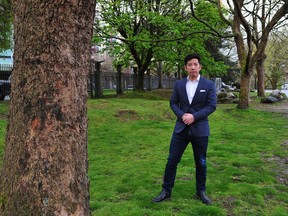 Michael Tan of the Chau Luen Society poses outside 325 Keefer St. in Vancouver, with trees the society is hoping to cut down for property development.
