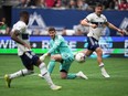 Toronto FC goalkeeper Alex Bono, centre, watches as Vancouver Whitecaps' Tosaint Ricketts, front left, scores after receiving a pass from Lucas Cavallini, back right, during the second half of an MLS soccer game in Vancouver, B.C., Sunday, May 8, 2022.