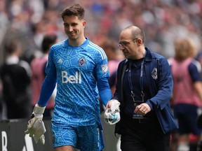 Vancouver Whitecaps goaltender Thomas Hasal leaves the field with an injury as Dr.  Dory Boyer supports his hand with a towel during the second half of an MLS soccer game against Toronto FC in Vancouver, BC, Sunday May 8, 2022. .