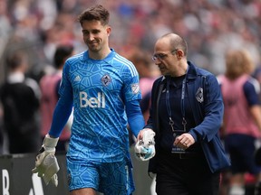 Vancouver Whitecaps goaltender Thomas Hasal leaves the field with an injury as Dr. Dory Boyer supports his hand with a towel during the second half of an MLS soccer game against Toronto FC in Vancouver, BC, Sunday May 8, 2022. .