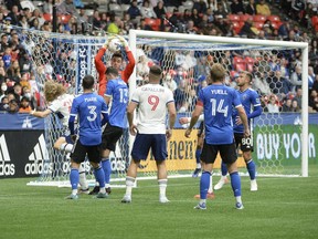 San Jose Earthquakes goaltender JT Marcinkowski (1) jumps to stop a Vancouver Whitecaps corner kick during the first half at BC Place.