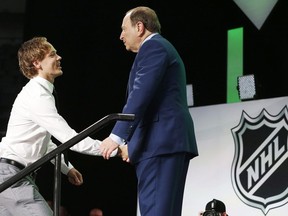 Filip Johansson (left) is greeted by NHL Commissioner Gary Bettman after being selected by the Minnesota Wild during the NHL hockey draft in Dallas, Friday, June 22, 2018.