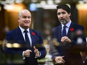 In this multiple-exposed image, Conservative Leader Erin O'Toole (left) asks a question and Prime Minister Justin Trudeau answers during question period on Nov. 4, 2020.