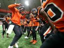 Garry Peters (1) and his BC Lions' teammates celebrate an interception with defensive coordinator Ryan Phillips against the Edmonton Elks.