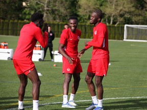 Alphonso Davies, left, Sam Adekugbe and Iké Ugbo share some laughs at the National Training Centre at UBC on Tuesday.