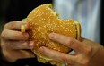 A man eats a Whopper during the opening of the first European Whopper Bar on June 15, 2009 in Munich, Germany. (Photo by Miguel Villagran/Getty Images)