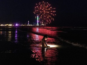 RayLynn Blizzard, 5, of Corsicana, Texas, wears a headlamp while playing on the beach during Juneteenth celebration fireworks in Galveston, Texas, June 19, 2021.
