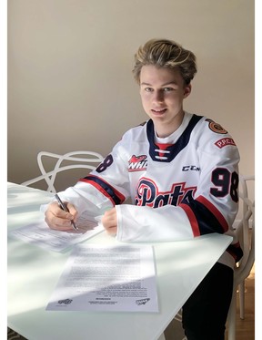 A 14-year-old Connor Bedard signs on the dotted line with the WHL’s Regina Pats in the spring of 2020. ‘He’s only young by number. He’s very mature,’ says Hockey Canada director of player personnel Alan Millar.