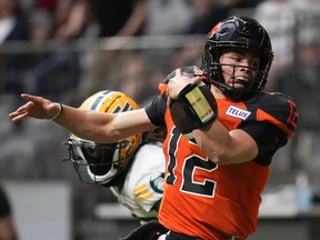 B.C. Lions quarterback Nathan Rourke is pushed out of bounds by Edmonton Elks' Jalen Collins as he runs with the ball during the first half of CFL football game in Vancouver, on Saturday, June 11, 2022.