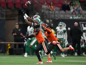 Saskatchewan Roughriders' D'haquille Williams, back left, reaches but fails to make the reception as B.C. Lions' T.J. Lee (6) and Garry Peters (1) defend during the first half of a pre-season CFL football game in Vancouver, B.C., Friday, June 3, 2022.