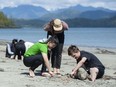 Students from West Point Grey Academy work on fire-making skills on the beach near the Cedar Coast Field Station on Vargas Island. Photo: Jason Payne/PNG.