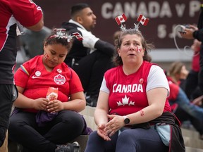 Disappointed Canadian soccer fans sit outside B.C. Place Stadium on Sunday, June 5, as news comes through that the national men's team's match against Panama has been cancelled due to a labour dispute between the team and Canada Soccer, the sport's national body.