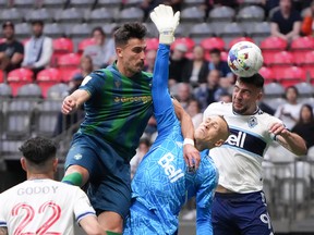 Vancouver Whitecaps’ Lucas Cavallini, back right, gets his head on the ball as goalkeeper Cody Cropper, centre, right, reaches for it in front of York United’s Dominick Zator, back left, during the first half of a Canadian Championship semifinal soccer match, in Vancouver, on Wednesday, June 22, 2022.