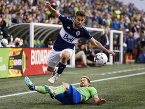 Jun 14, 2022; Seattle, Washington, USA; Vancouver Whitecaps defender Marcus Godinho (2) evades a slide tackle attempt by Seattle Sounders FC midfielder Kelyn Rowe (22) during the first half at Lumen Field. Mandatory Credit: Joe Nicholson-USA TODAY Sports