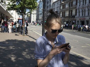A person smoking and texting along Oxford Street in London, England, United Kingdom. Photographer: Mike Kemp/In Pictures/Getty Images