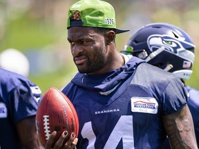 Seattle Seahawks' DK Metcalf holds a football during NFL training camp Wednesday, July 27, 2022, in Renton, Wash.