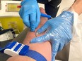 A person donates blood at the Canadian Blood Services donation centre in Kingston, Ont., Feb. 3, 2022.