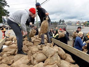 People fill sandbags in Abbotsford during November's floods. Riverside communities are stepping up flood preparations again as the Fraser River continues to rise.